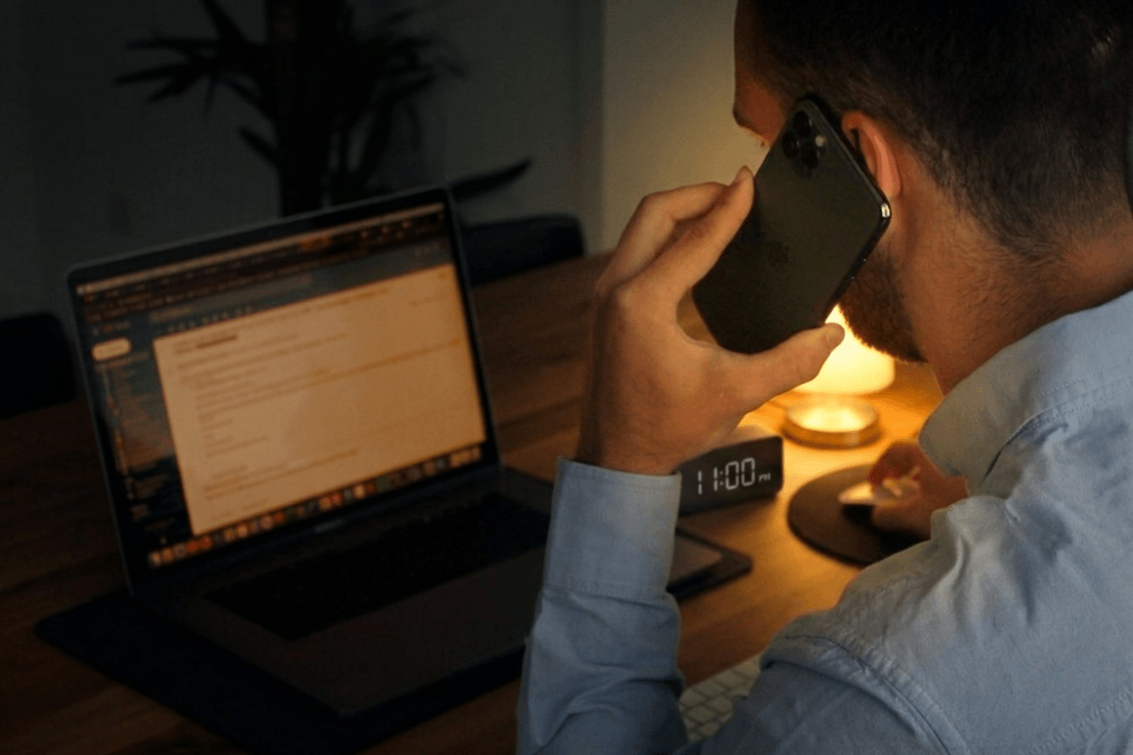 Person taking a late-night phone call at a desk after clinic hours