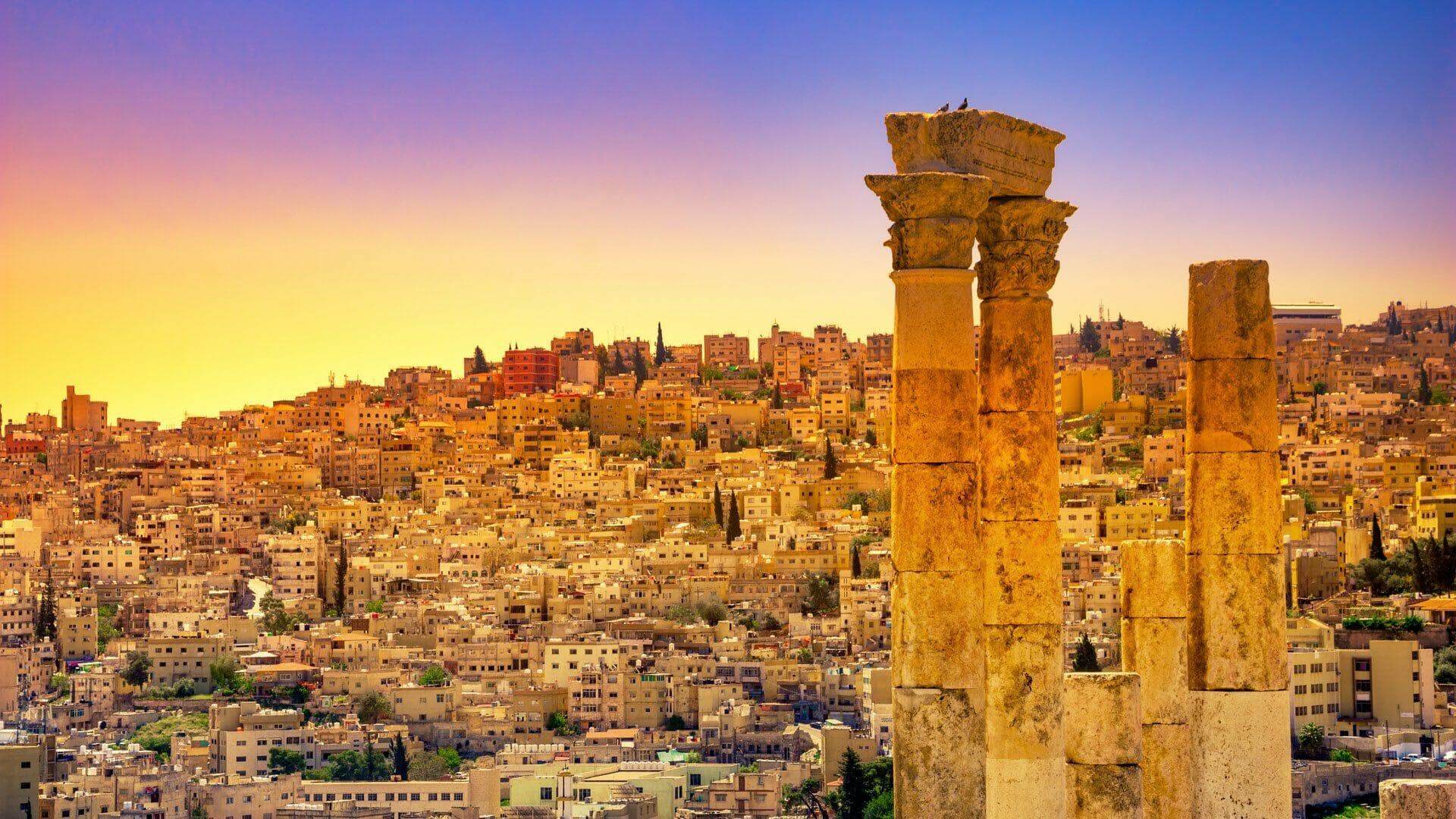 Amman skyline at sunset with Roman columns